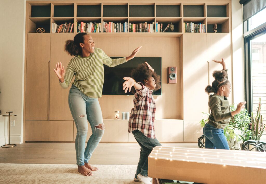 mother dancing with her children in a living room